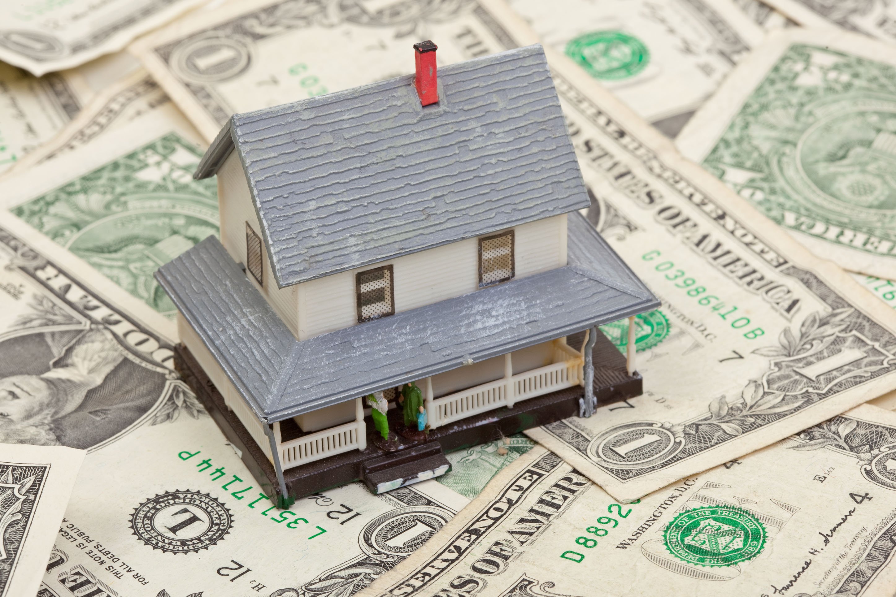 Image of a home on top of dollar bills