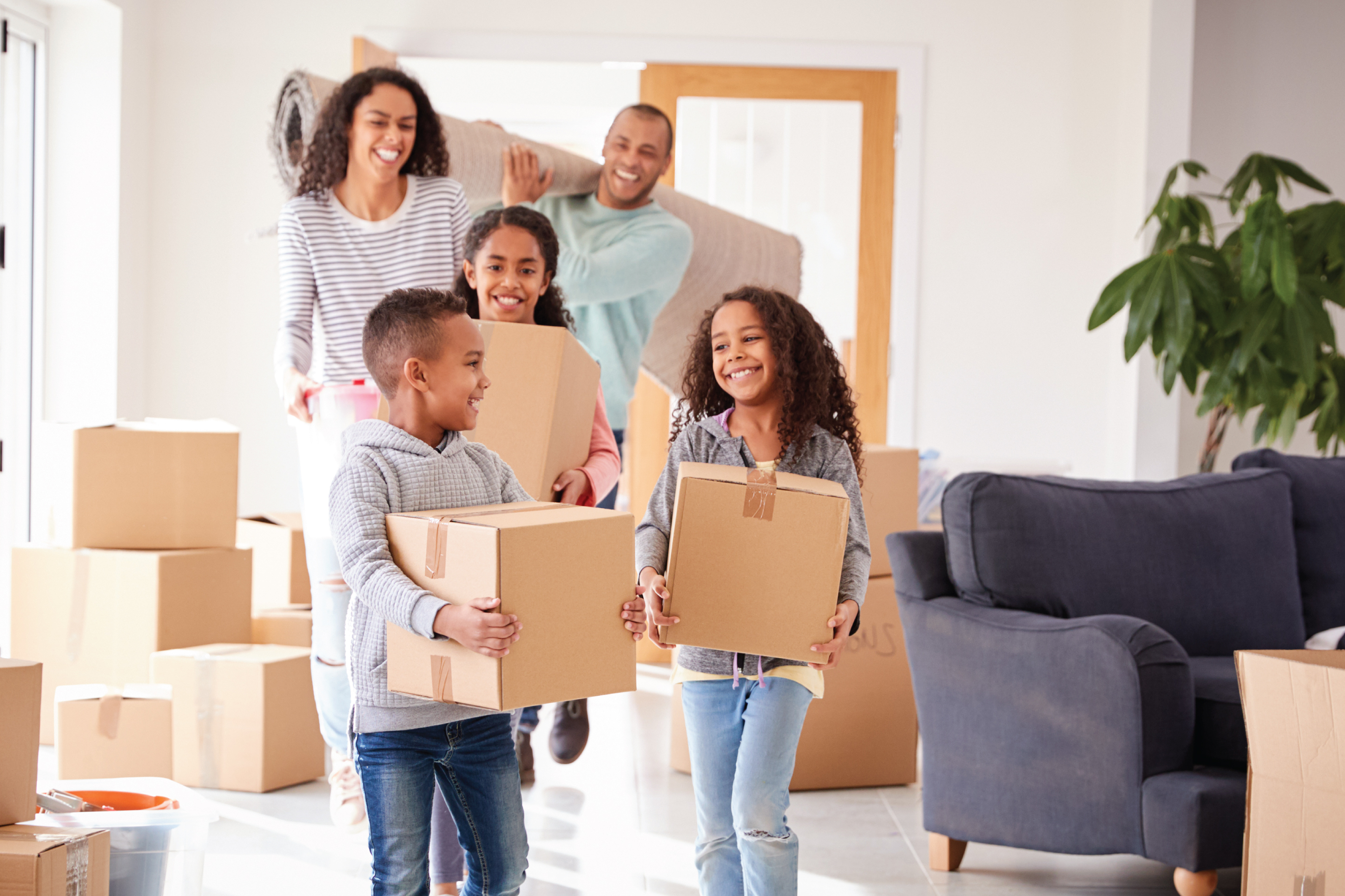 a family bringing moving boxes into their new home