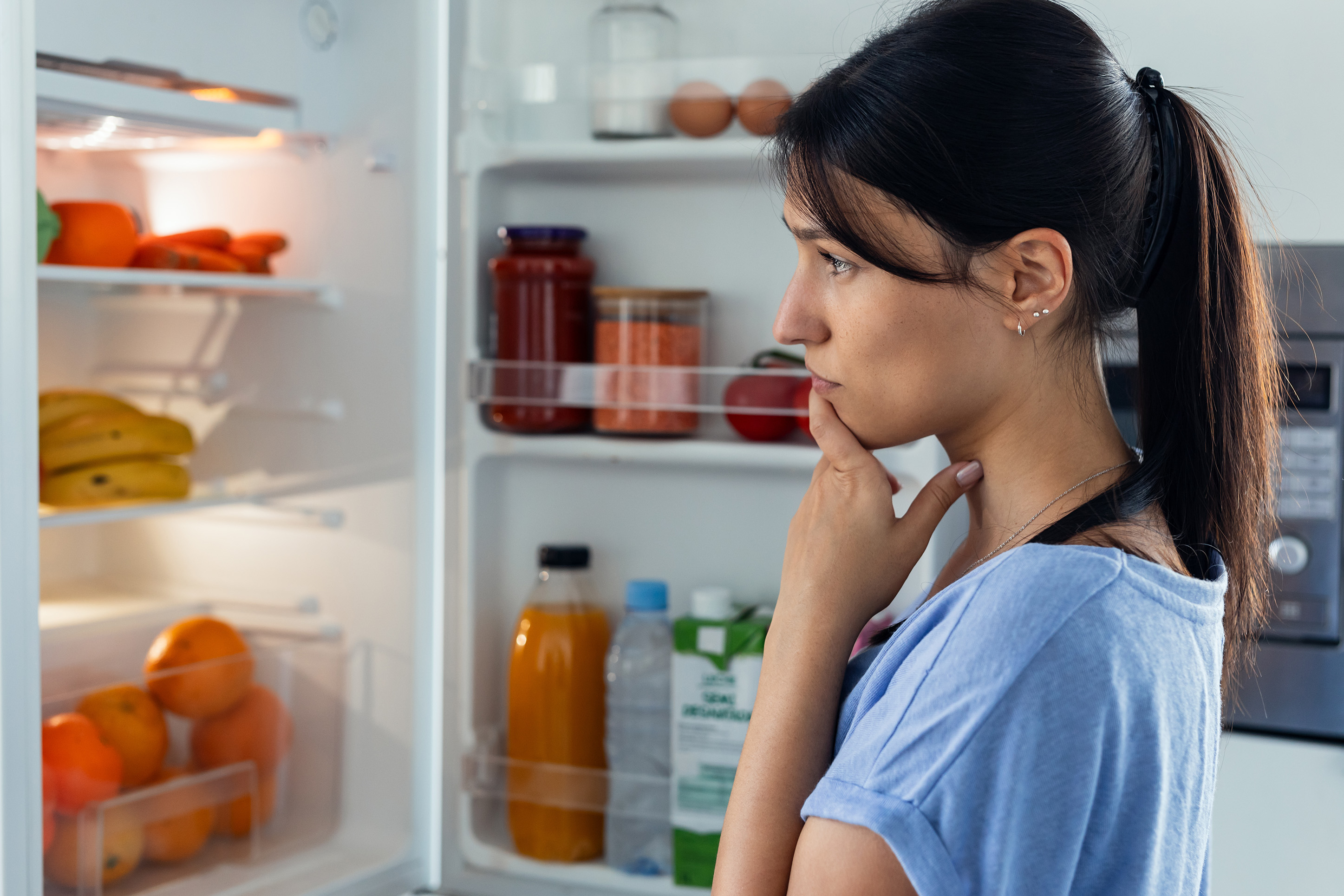 Woman looking at food in the refrigerator