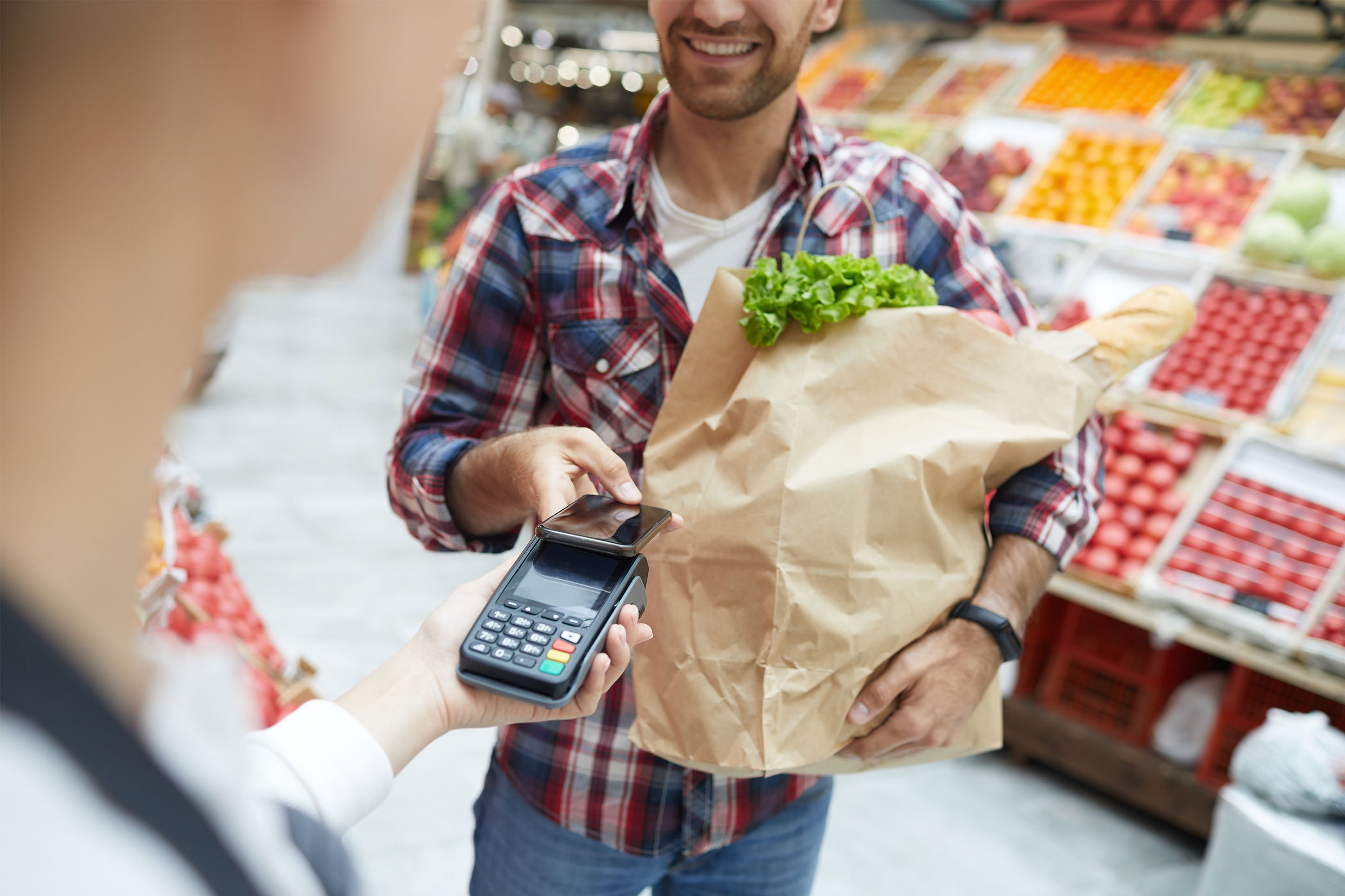man using his credit card to pay for groceries