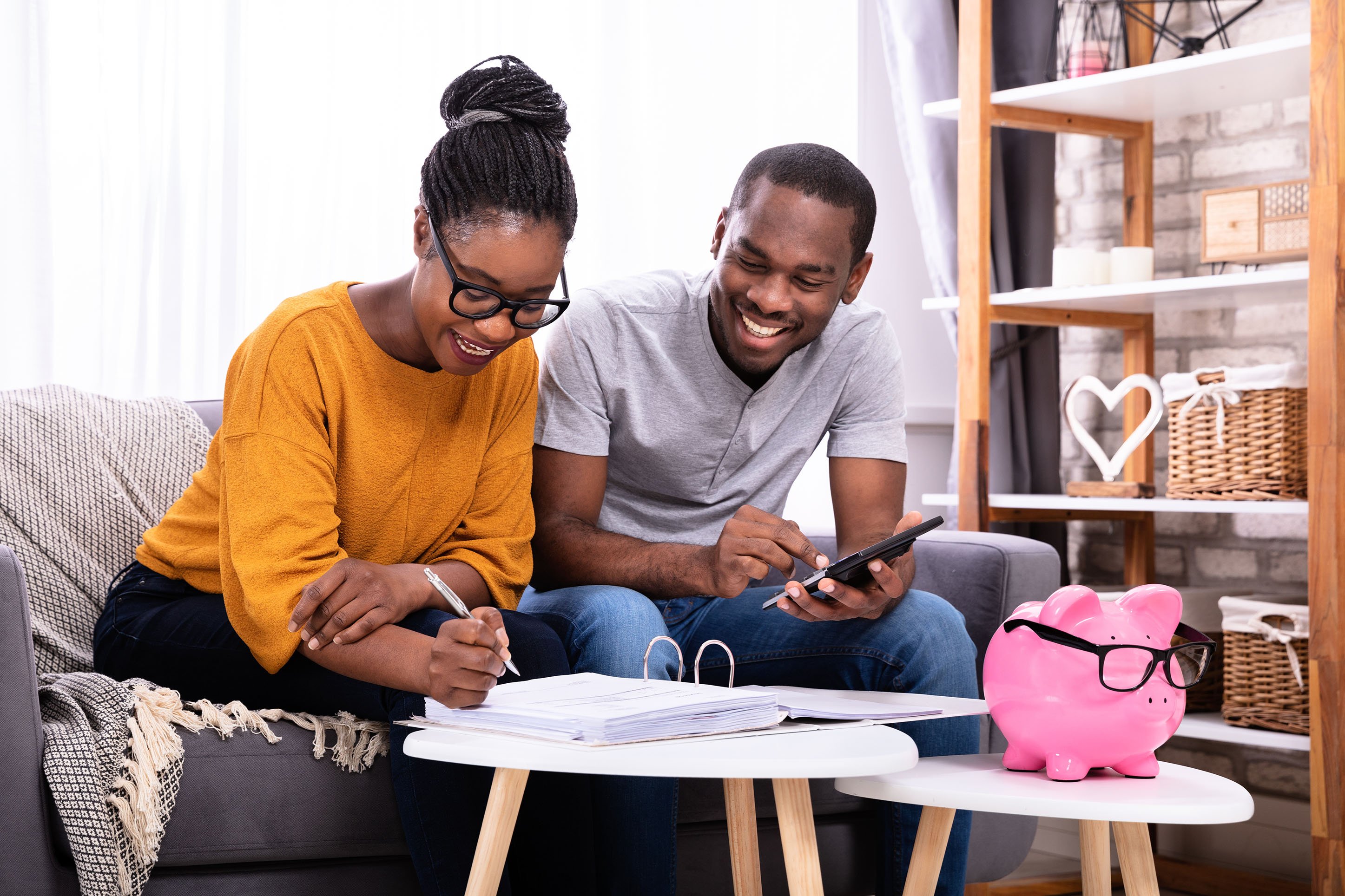 A couple reviewing finances with a piggy bank in front of them. 