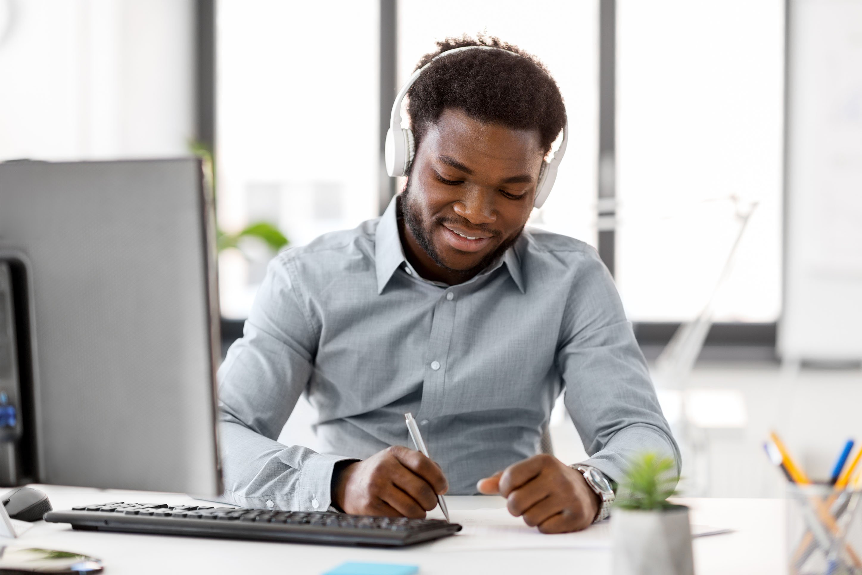 Man wearing headphones working on finances. 