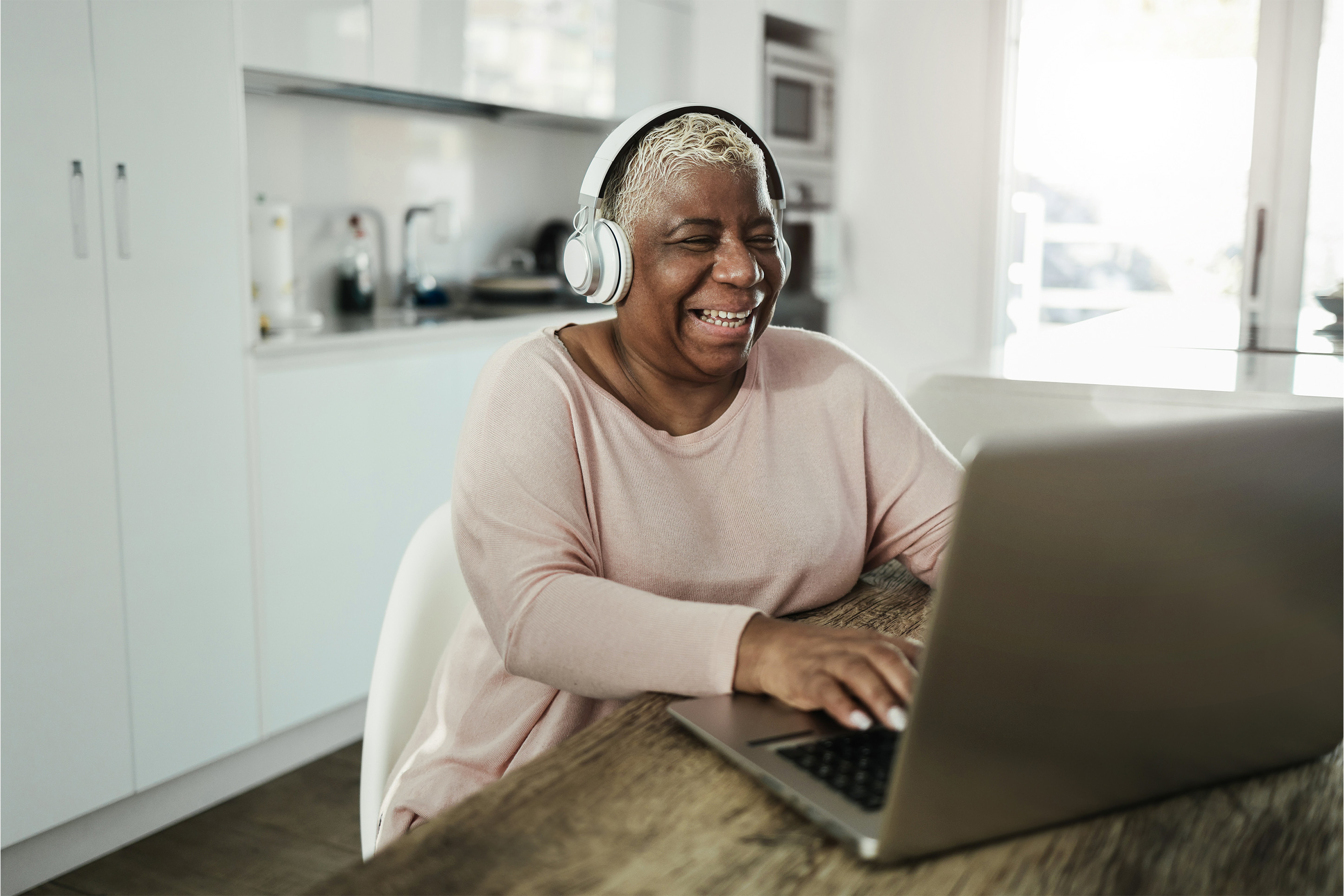 Woman listening to a podcast on a computer with headphones. 