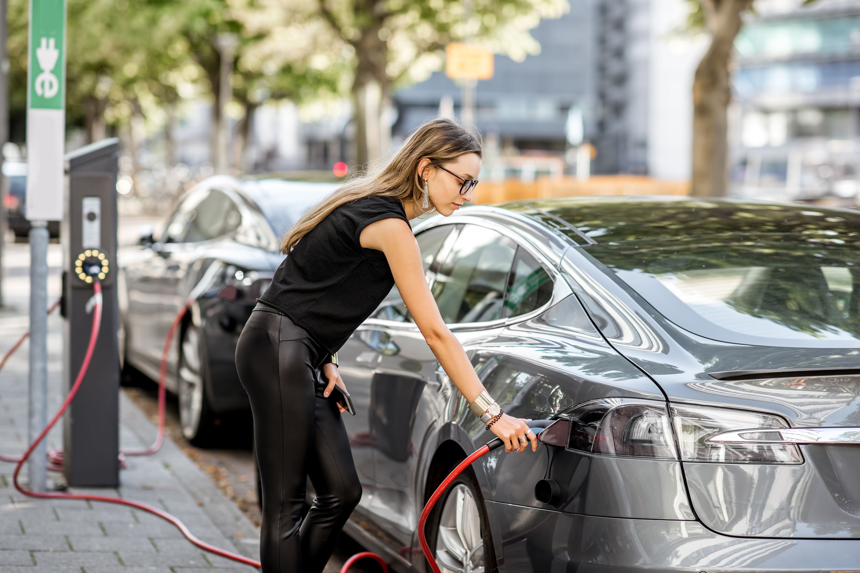 Woman charging an electric car. 