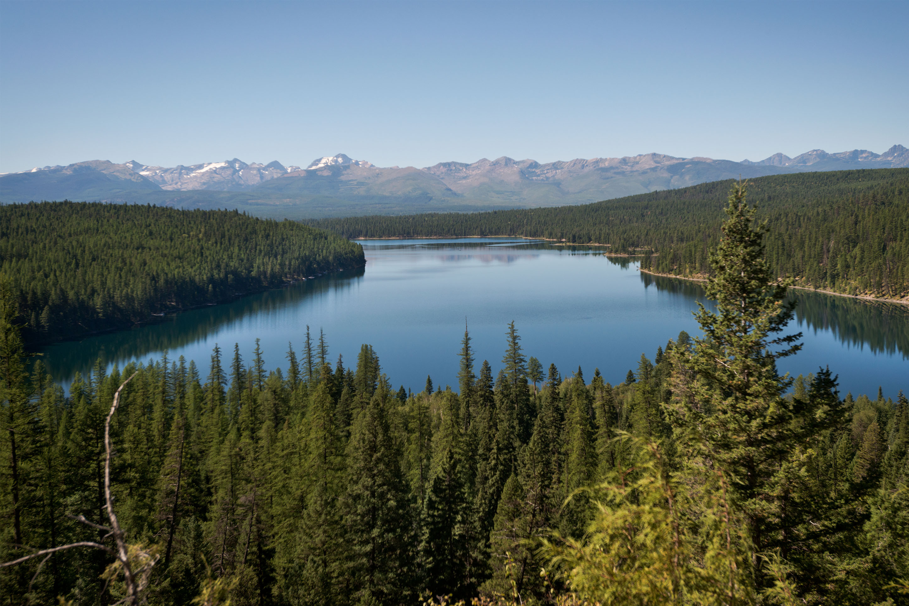 Photo of a lake in Montana with snow-capped mountains in background. 