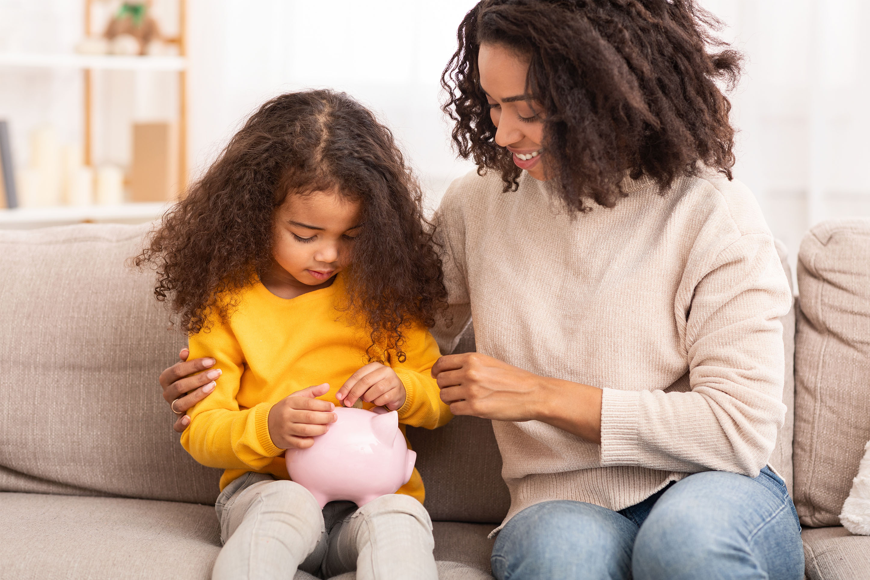 Mother and daughter with a piggy bank. 